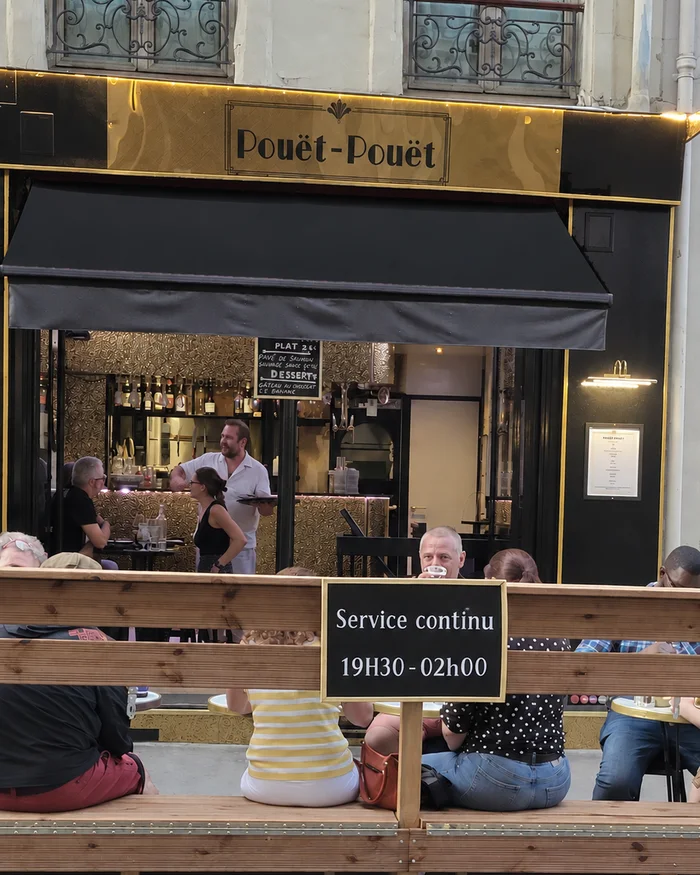 La façade de Pouët-Pouët en soirée, avec son ardoise des horaires